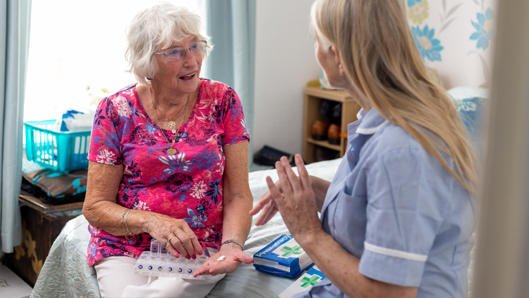 Nurse discussing medicine with older patient. 