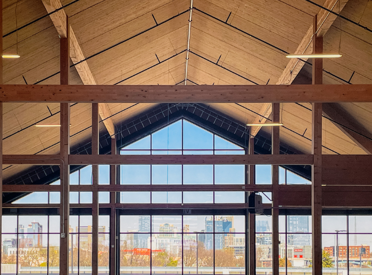 Engineered wood structure featuring warm wood paneling, timber columns, and large overhead wood panels.