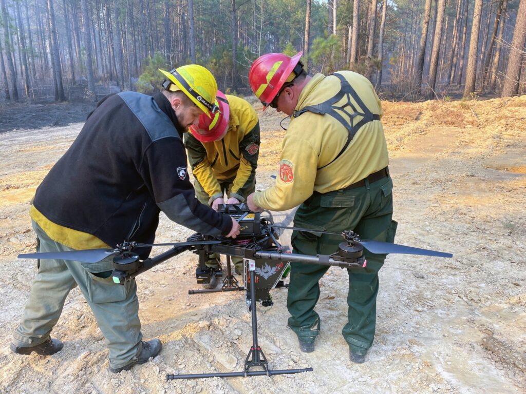 wildland firefighters work together on drone on fireline