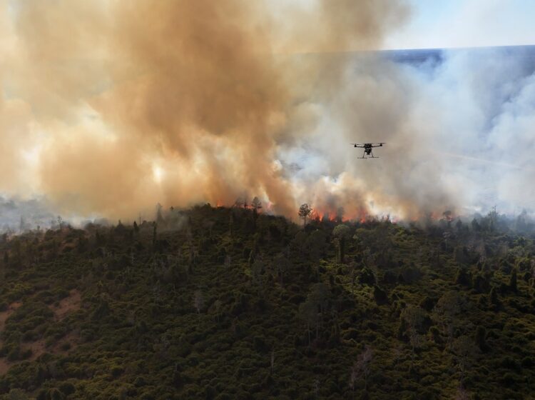 Aerial photo of wildfire with a drone flying amid the smoke
