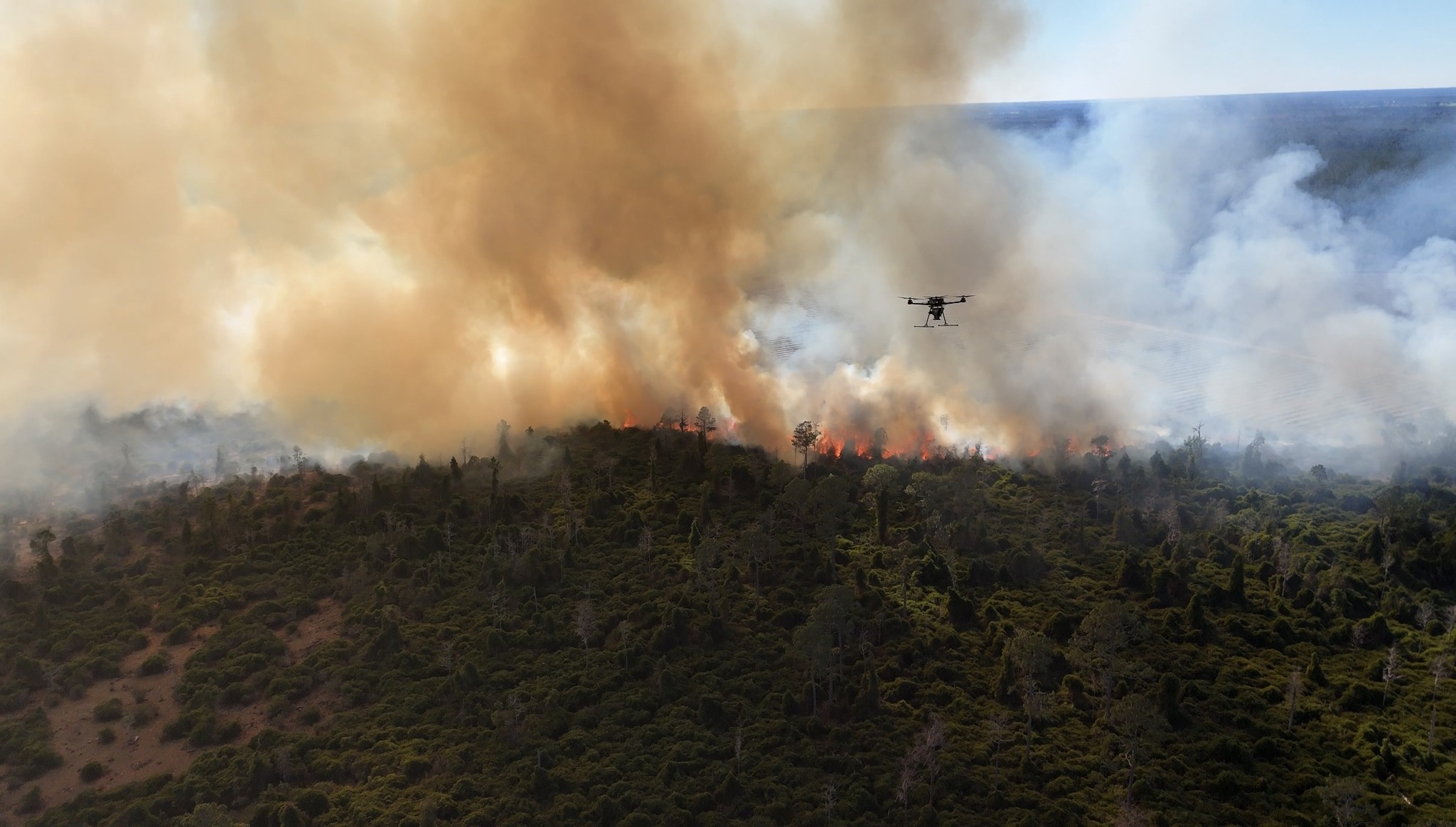 Aerial photo of wildfire with a drone flying amid the smoke